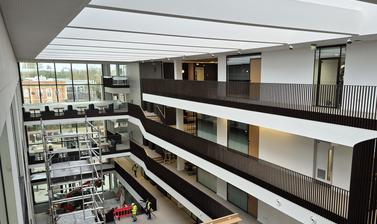Main atrium of the Life and Mind Building from the upper floor, looking towards the main entrance, largely completed but with some scaffolding and construction work ongoing